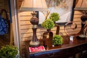 25% off home decor display with lamps, plant stands, and more