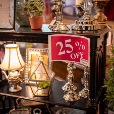 25% off home decor display with small lamps, picture frames, candlestick holders, and more