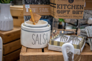 kitchen themed items for sale including dishtowels and discloths, a salsa container, and forks